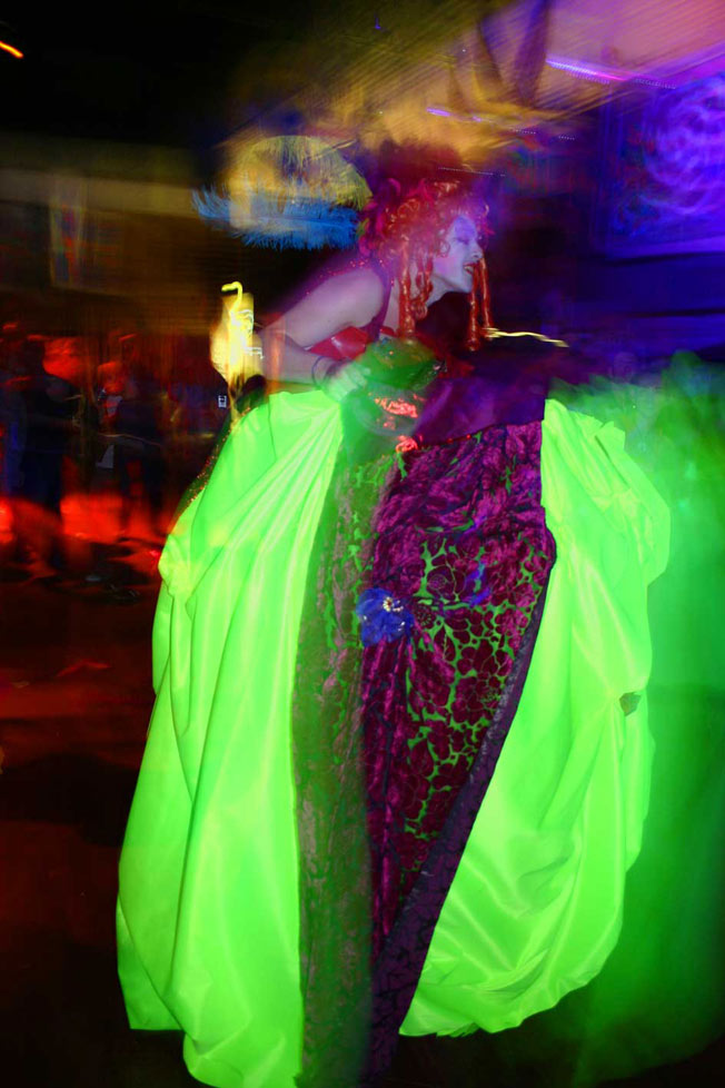 A Stilt walker in a drag costume with a shadow puppet theatre consealed beneath the dress